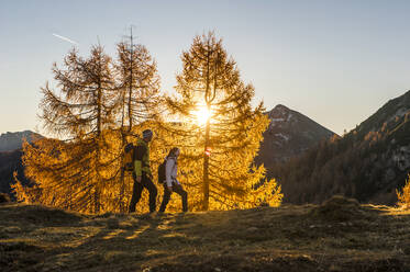 Two people hiking in Ennstal Alps at autumn sunset - HHF05806