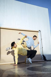 Male performers balancing while dancing near backdrop - RCPF01400