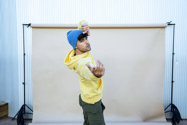 Junger männlicher Tänzer, der in der Nähe der Kulisse auftritt - RCPF01412