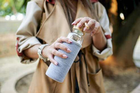 Woman holding reusable glass bottle - KIJF04183