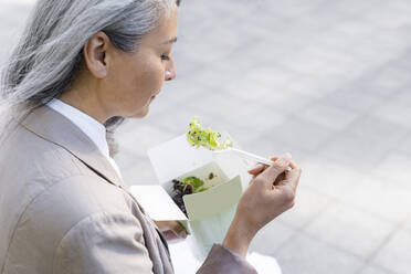 Frau mit grauem Haar isst Salat - OIPF01306