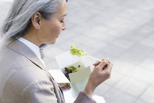 Frau mit grauem Haar isst Salat - OIPF01306
