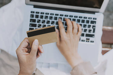 Mature woman holding credit card while using laptop - OIPF01314