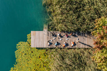 Frauen und Männer beim Yoga auf dem Steg am See - DAWF02007