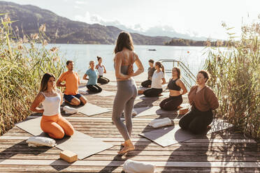 Weibliche Lehrerin unterrichtet Pashchima Namaskarasana während einer Yogastunde - DAWF02041