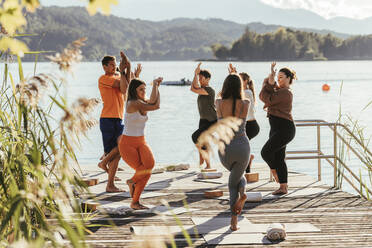 Weibliche Lehrerin unterrichtet die Adlerpose während einer Yogastunde - DAWF02048