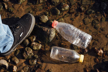 Plastic bottles floating on water by man - VPIF05105