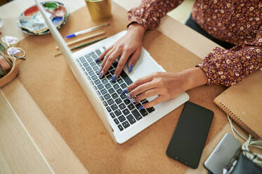 Young businesswoman typing on laptop at desk - KIJF04224