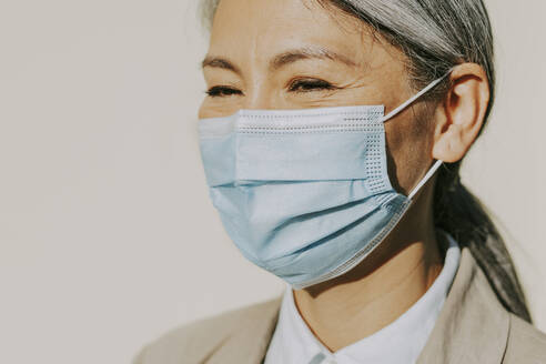 Mature woman wearing protective face mask during pandemic - OIPF01353