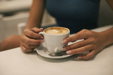 Junge Frau mit manikürten Nägeln bei einem Kaffee im Café - ACPF01362