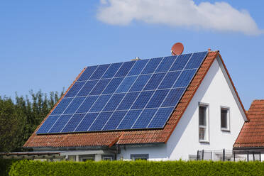 Haus mit Ziegeldach, das mit Sonnenkollektoren bedeckt ist - WIF04453