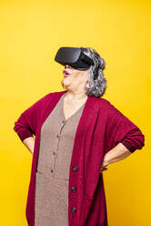 Frau mit Virtual-Reality-Headset vor gelbem Hintergrund - GPF00083