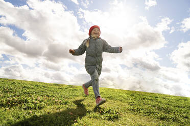 Carefree girl running on grass during sunny day - SSGF00073