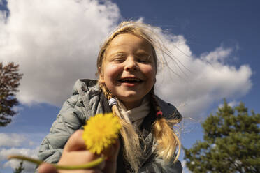 Glückliches Mädchen hält Blume beim Spielen im Park - SSGF00078