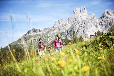 Glückliche Familie beim Wandern vor einem Berg an einem sonnigen Tag - HHF05817