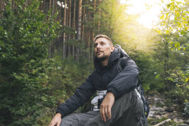 Männlicher Tourist, der im Wald nachdenkt - JCCMF04326