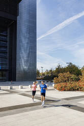 Male and female athletes running on footpath - IFRF01110