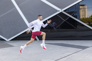 Fitter männlicher Sportler beim Laufen auf dem Fußweg - IFRF01173