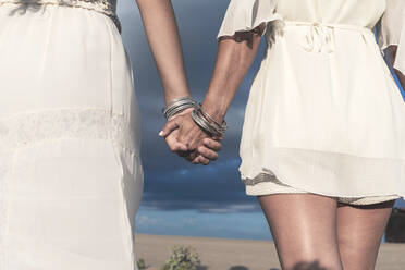 Lesbisches Paar hält Hände an einem sonnigen Tag - RFTF00127