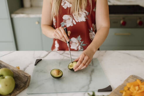 Diätassistentin schneidet Avocado auf dem Küchentisch - SMSF00592