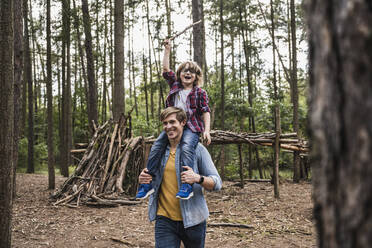 Glücklicher Vater trägt seinen Sohn im Wald auf den Schultern - UUF24880