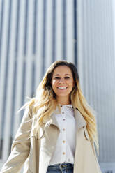 Smiling female freelancer in front of building - PGF00842