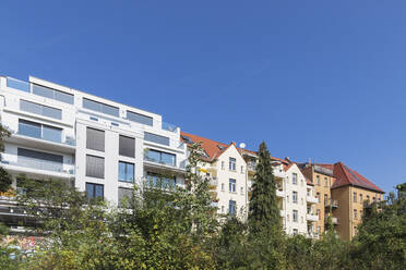 Deutschland, Sachsen, Leipzig, Klarer blauer Himmel über einer Reihe von neuen und alten Wohnhäusern - GWF07218