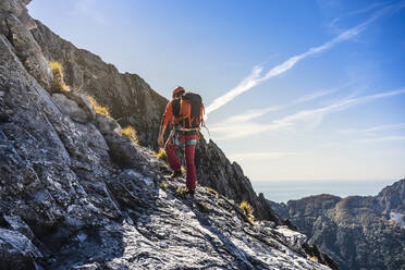 Männlicher Alpinist beim Wandern auf einem abenteuerlichen Bergpfad - MCVF00918