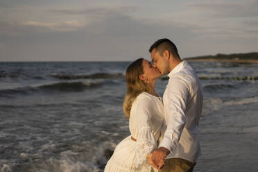 Junges Paar küsst sich auf den Mund am Strand am Meer - SSGF00090