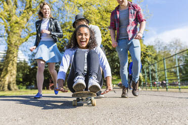 Junge Frau spielt mit Freunden im Park - WPEF05465