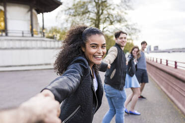 Young woman enjoying with friends on footpath in park - WPEF05487