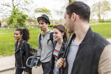 Gemischtrassige Gruppe junger Freunde, die zusammen im Park spazieren gehen - WPEF05504