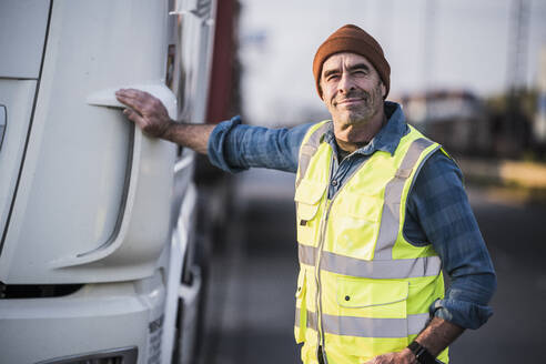 Smiling male driver standing by truck - UUF24971