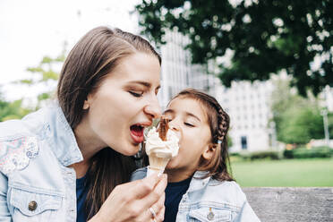 Mutter und Tochter teilen sich ein Eis im öffentlichen Park - ASGF01663