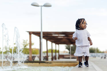 Girl walking by fountain - PGF00870