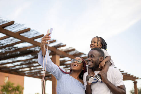 Lächelnde Familie nimmt Selfie durch Mobiltelefon - PGF00893