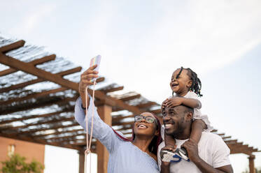 Glückliche Familie nimmt Selfie durch Smartphone - PGF00894