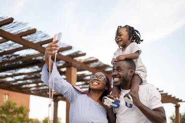 Woman taking selfie with family by roofing - PGF00895