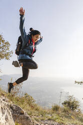 Young woman jumping in the mountains - MRAF00706