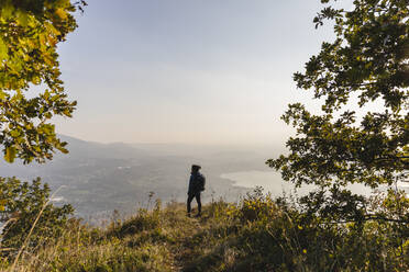 Wanderer steht auf einem Berggipfel und betrachtet die Aussicht - MRAF00709