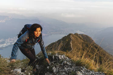 Lächelnder Wanderer beim Klettern am Berg - MRAF00729
