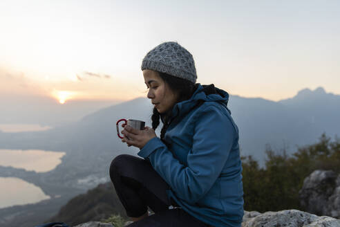 Frau trinkt Kaffee auf einem Berg - MRAF00739