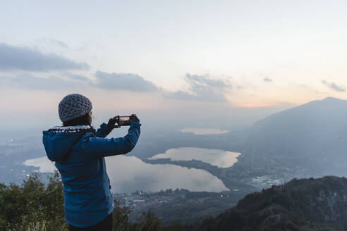 Wanderer fotografiert mit seinem Smartphone auf einem Berg - MRAF00748