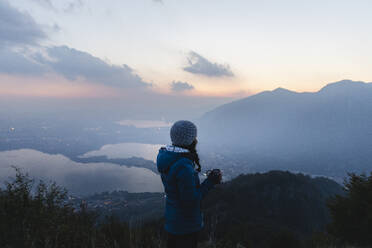 Junge Frau mit Blick auf einen Berg bei Sonnenuntergang - MRAF00756