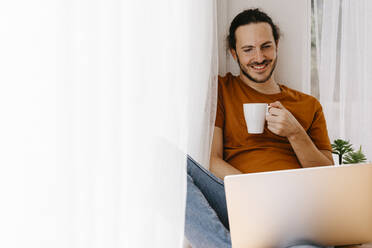 Man having coffee while working at home - TCEF02091