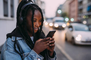 Smiling woman using mobile phone on road - MEUF04639