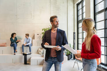 Geschäftsmann im Gespräch mit einem Mitarbeiter im Büro - DIGF16623