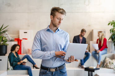 Geschäftsmann mit Laptop in einem Coworking-Büro - DIGF16626