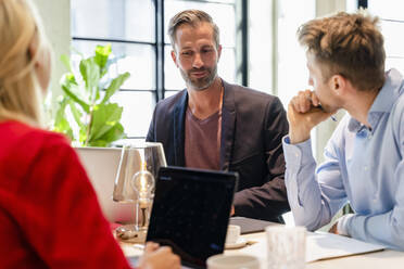 Businessman discussing with coworkers in meeting at office - DIGF16643