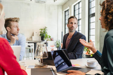 Businesswoman having discussion with colleagues in office - DIGF16647